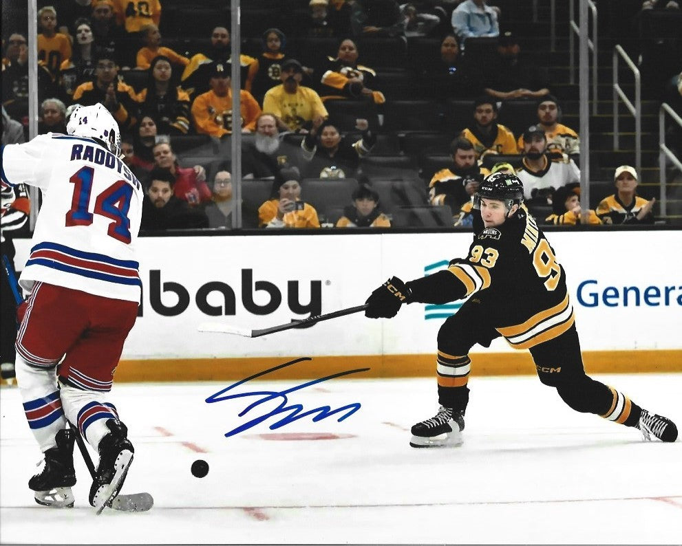 An autographed sports photo print of Boston Bruins star Fraser Minten making a slapshot, with a player's signature in blue ink at the bottom.