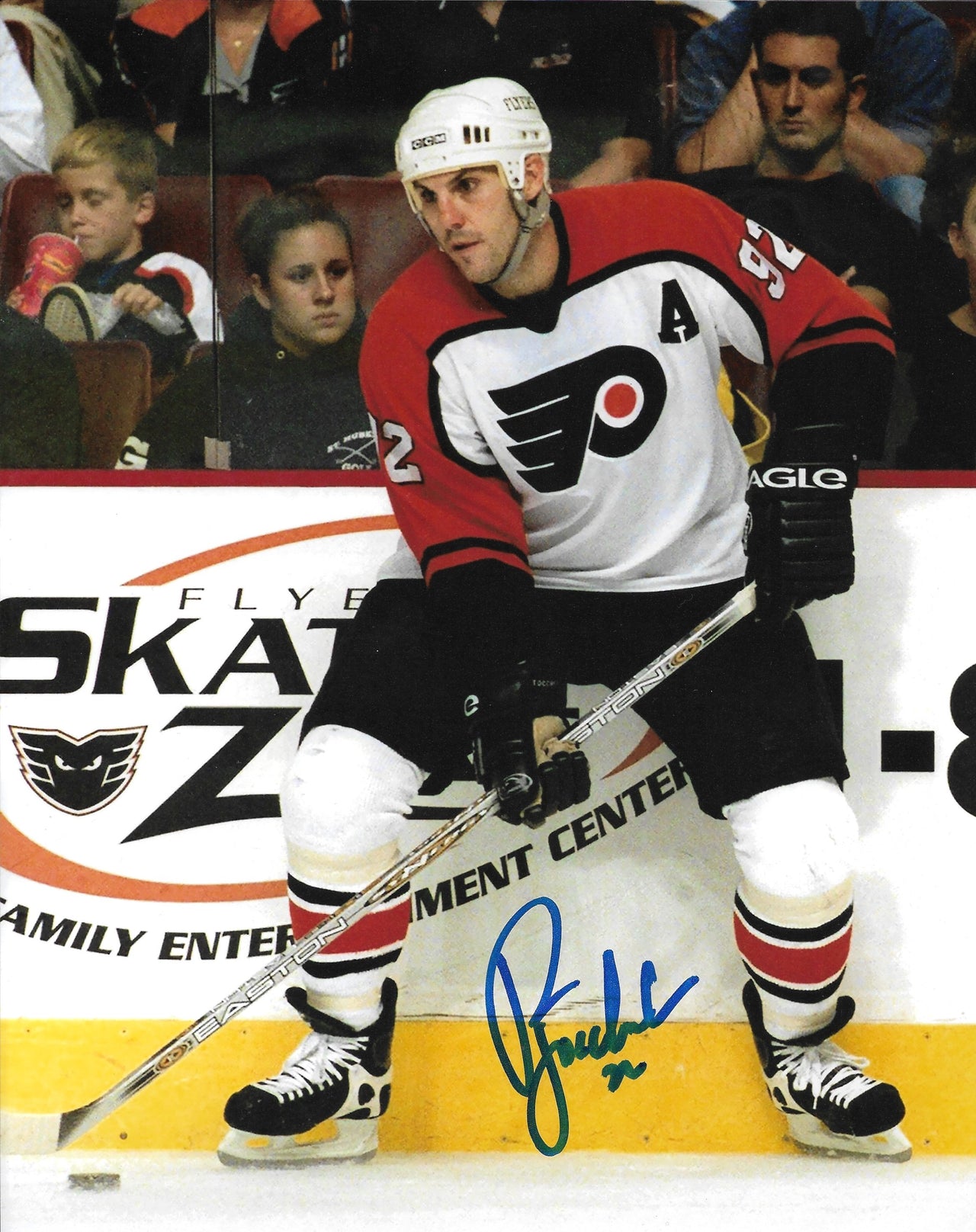 Philadelphia Flyers legend Rick Tocchet in action with a visible signature on the photo