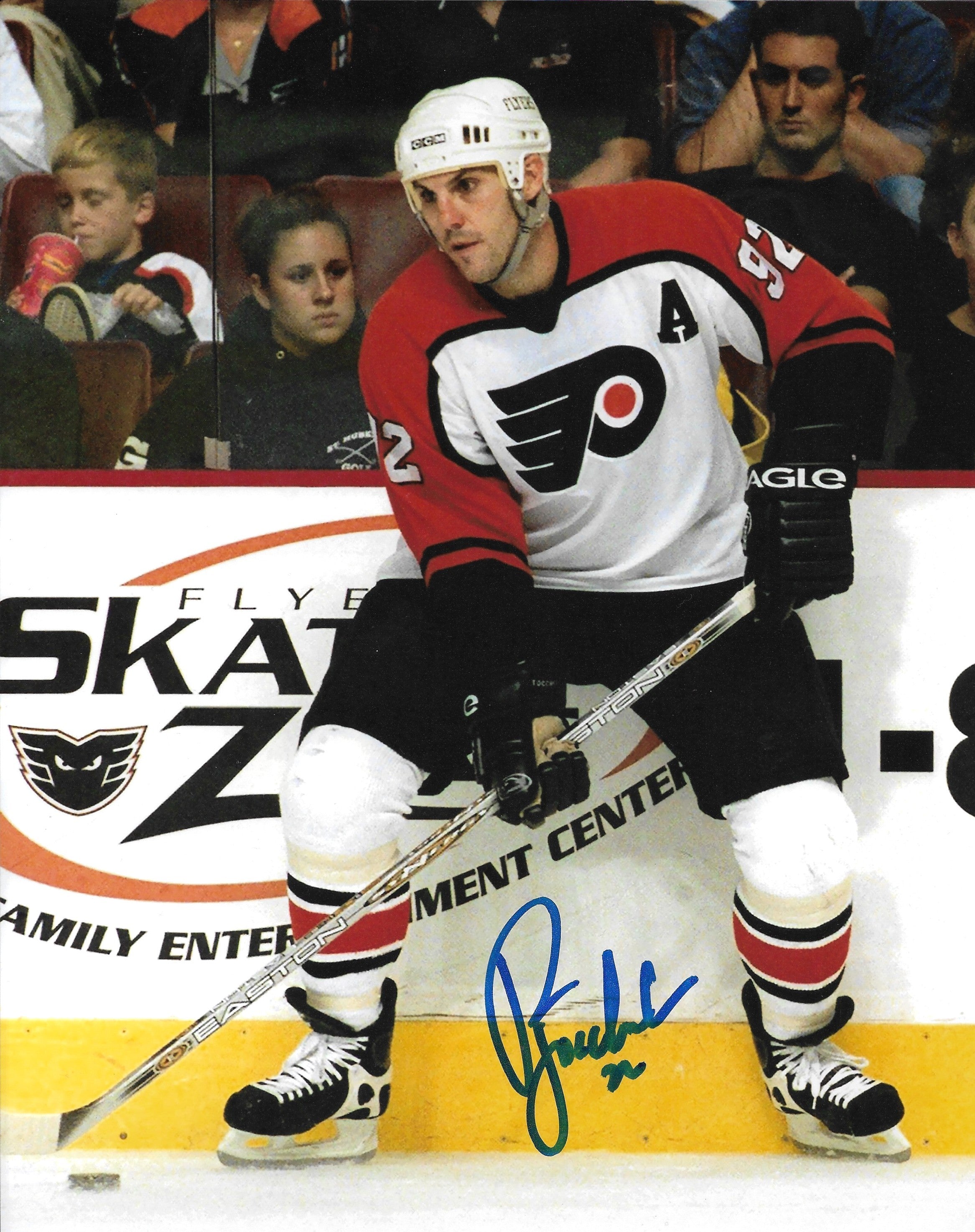 Philadelphia Flyers legend Rick Tocchet in action with a visible signature on the photo