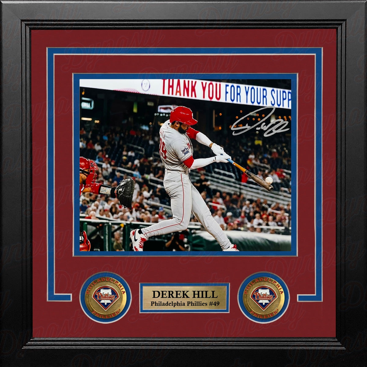 Framed 8x10 baseball memorabilia featuring a signed action photo of Derrek Hill, Philadelphia Phillies #49, batting at the plate. The print is matted with a dark red and blue double border and a black frame, with a gold nameplate and two circular team emblems at the bottom.
