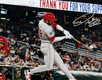 Philadelphia Phillies star Derek Hill in a gray and red uniform swings a bat at a ball in a stadium, with a catcher in red partially visible on the left. The image includes a large autograph overlay in the upper right.