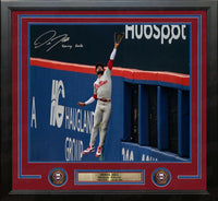 Framed sports memorabilia featuring a signed and autographed photo of baseball player Derek Hill robbing Juan Soto of a home run. The print is matted with a dark red and blue border and includes a gold-toned plaque at the bottom with the Philadelphia Phillies team logo.