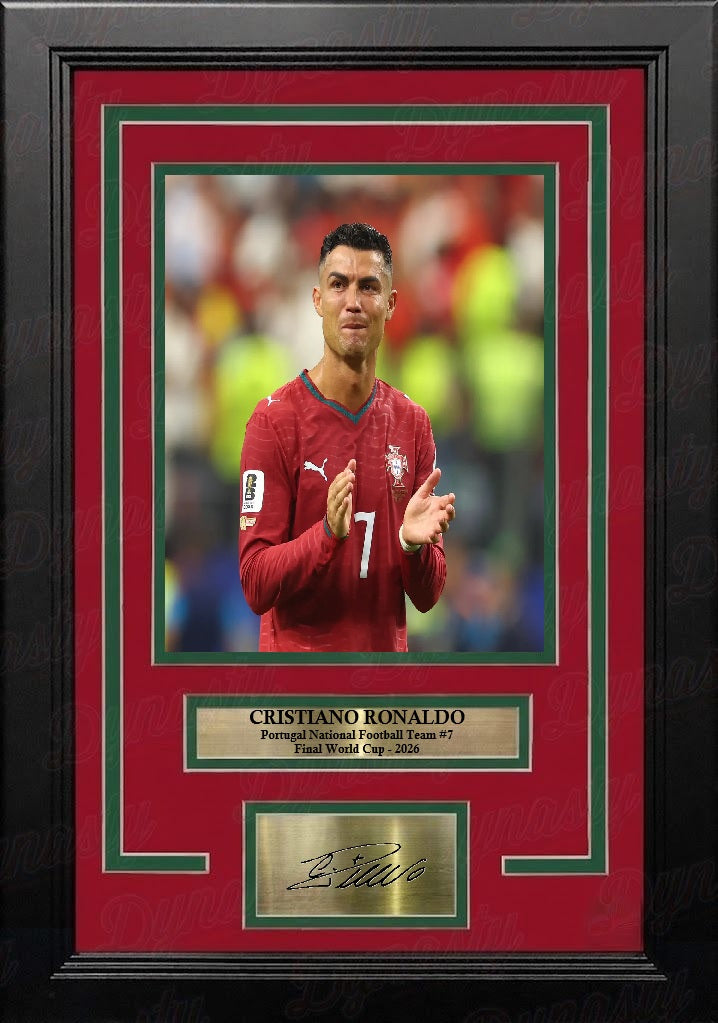 Framed Cristiano Ronaldo photo featuring a portrait of the player in a Portugal national team jersey, with a red mat, green inner border, black frame, and gold-toned nameplate and signature plaque. It shows Ronaldo celebrating his final World Cup match in 2026.