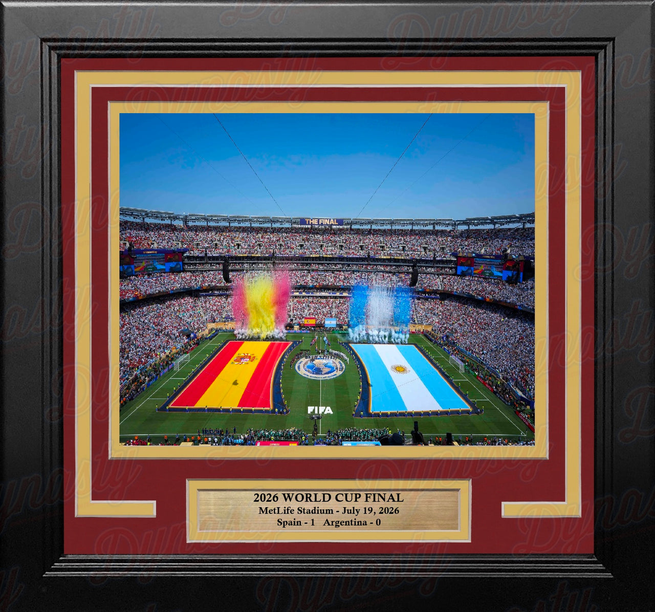 Framed 2026 World Cup Final commemorative print featuring a stadium scene with Spain and Argentina field markings, surrounded by a black frame with red and gold matting and a gold plaque at the bottom.